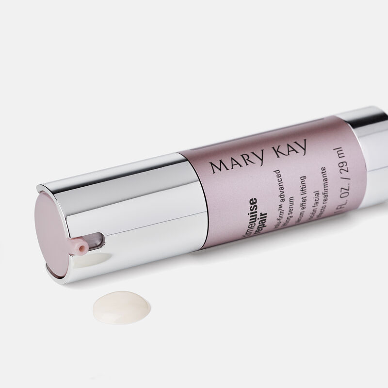 A bottle TimeWise Repair Volu-Firm Advanced Lifting Serum from Mary Kay laying on its side with product at its pump.