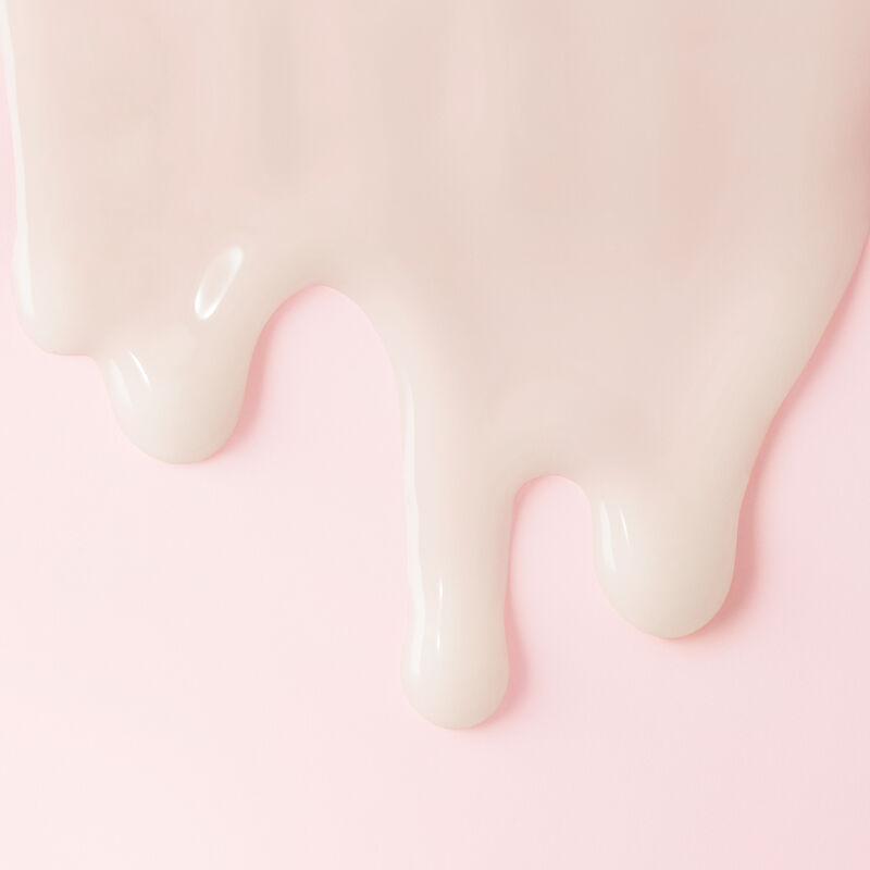 Extreme close up of TimeWise Replenishing Serum C + E from the Best-in-Brightness Bundle dripping down light pink background