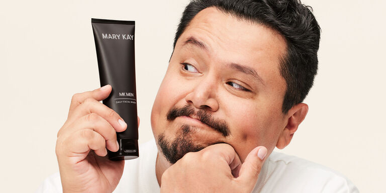 Modelo masculino sosteniendo el tubo de la Limpiadora Facial MKMen&reg; junto a su rostro