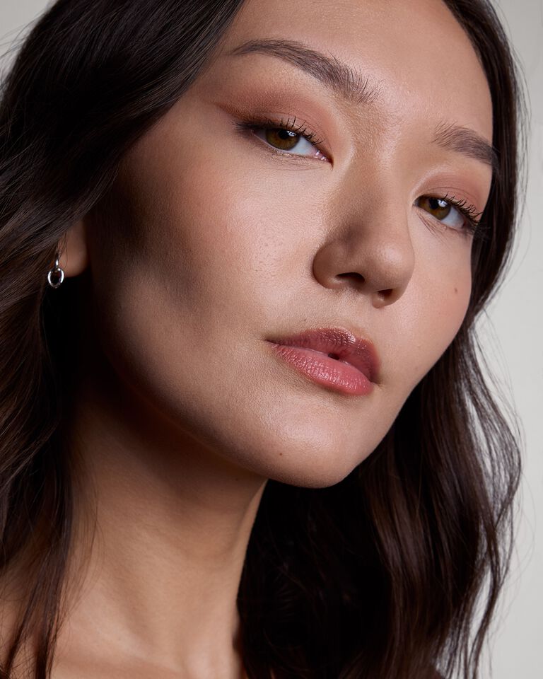 Close-up of a woman applying brown eyeliner