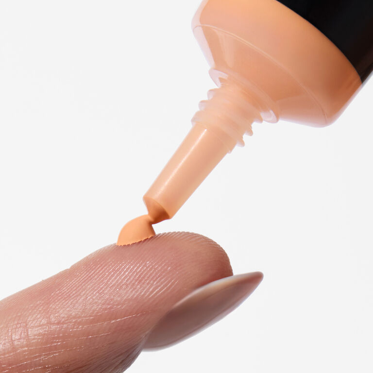 Punta fina del corrector undereye con una peque&ntilde;a cantidad de producto aplic&aacute;ndose en el dedo.