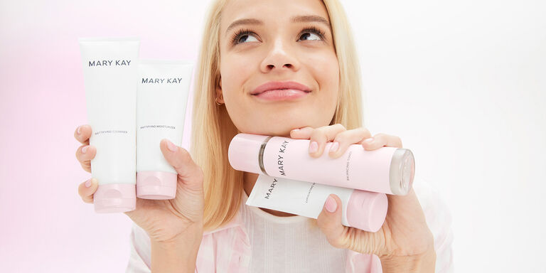 Modelo rubia sosteniendo los cuatro productos de la l&iacute;nea de cuidado de la piel Mary Kay&reg;