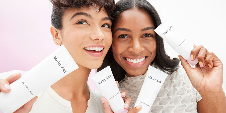 Dos modelos sosteniendo productos de la rutina de cuidado de la piel Mary Kay&reg; y sonriendo