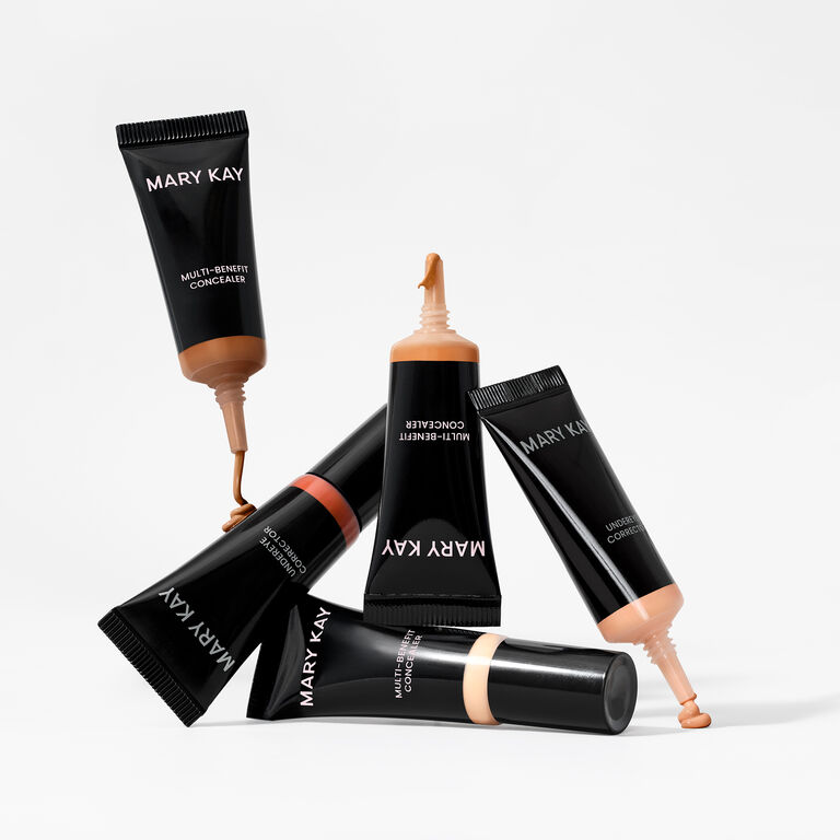 Mary Kay multi-benefit concealers in various shades arranged creatively on a white background.
