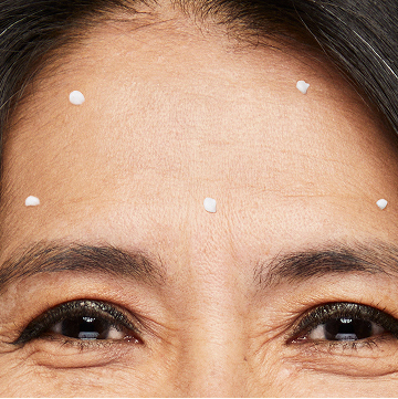 Mujer con cinco puntos de Reductor de Arrugas Din&aacute;micas Mary Kay Clinical Solutions sobre la frente.