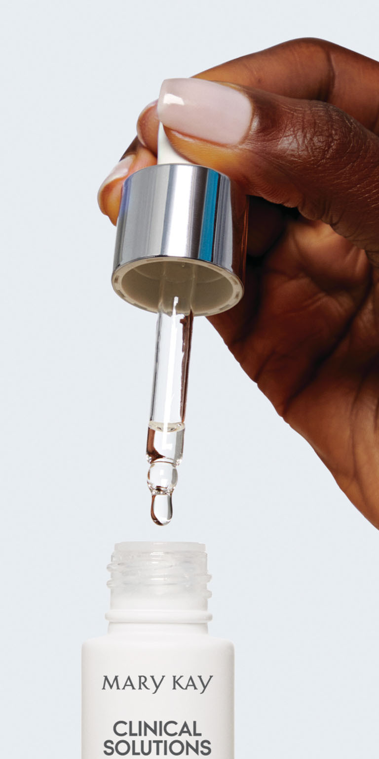 Modelo aplicando potenciador de Mary Kay Clinical Solutions con un cuentagotas.