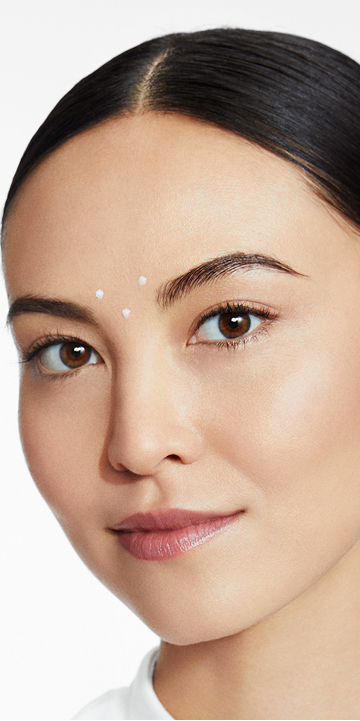 Mujer con tres puntos de Reductor de Arrugas Din&aacute;micas Mary Kay Clinical Solutions cerca de las cejas.
