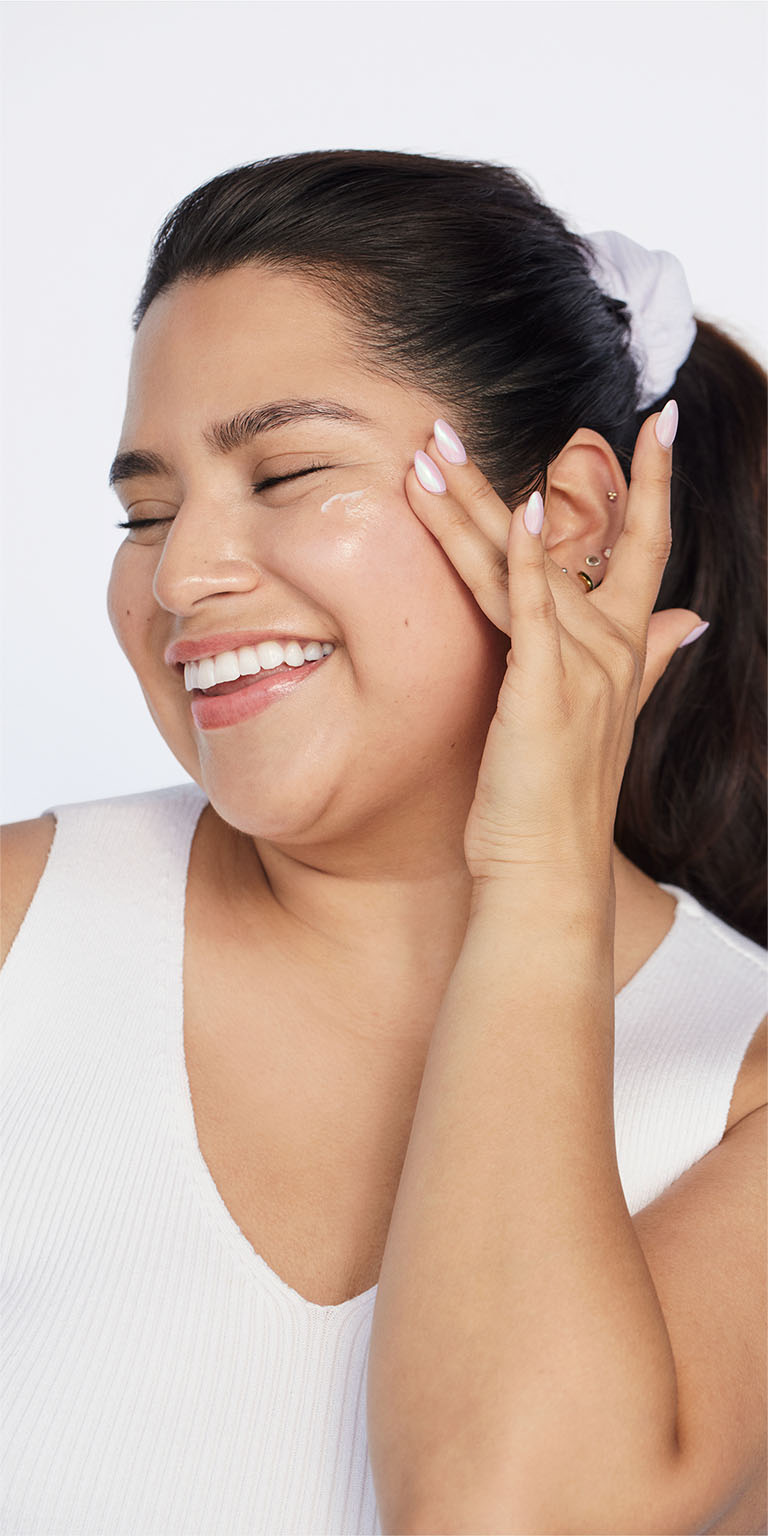 Mujer aplicando Protector Solar Facial Mineral FPS 30 Mary Kay en el lateral de su mejilla.